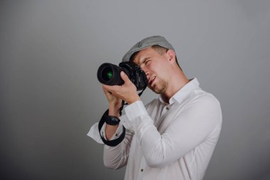 Stüdyoda profesyonel kamera kullanan genç adam.