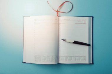 mavi arka plan üstünde defter. Açık günlüğü ve kaydetmek için kalem