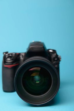 Mavi arka plana karşı profesyonel modern DSLR kamera