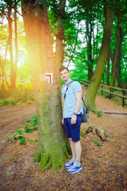 genç adam ormanda yanında ayakta