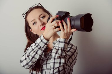 Görüntüleri gri arka plan üzerinde izole kadın-fotoğrafçı alır