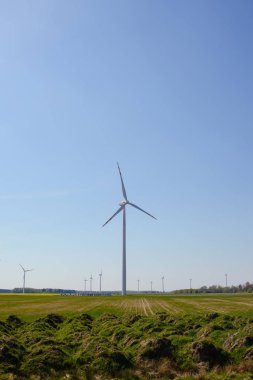 Parlak mavi gökyüzü hareket ediyor ve rüzgar türbini.