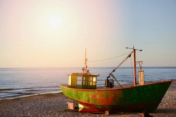 Gün doğumunda sahilde balıkçı tekneleri.