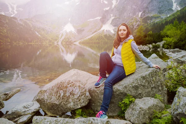 Kadın gölde ve dağlarda dinleniyor güneşli manzara.