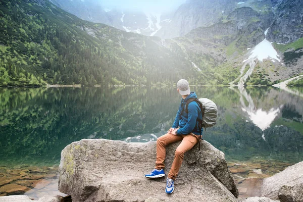 Adam gölde ve dağlarda dinleniyor. Güneşli manzara..
