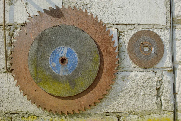 old circular saw on a brick wall.
