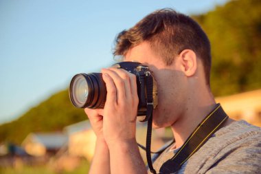 Sahilde genç fotoğrafçı silüeti. Yaz saati