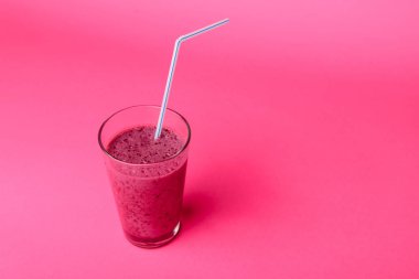 Pembe arka planda kahvaltıda taze böğürtlen, chia tohumu ve muz ile yabanmersini smoothie, seçici odak