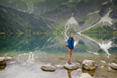 Adam gölde ve dağlarda dinleniyor. Güneşli manzara..