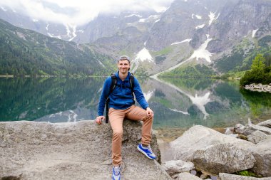Adam gölde ve dağlarda dinleniyor. Güneşli manzara..