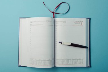 mavi arka plan üstünde defter. Açık günlüğü ve kaydetmek için kalem