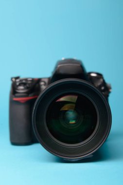 Mavi arka plana karşı profesyonel modern DSLR kamera
