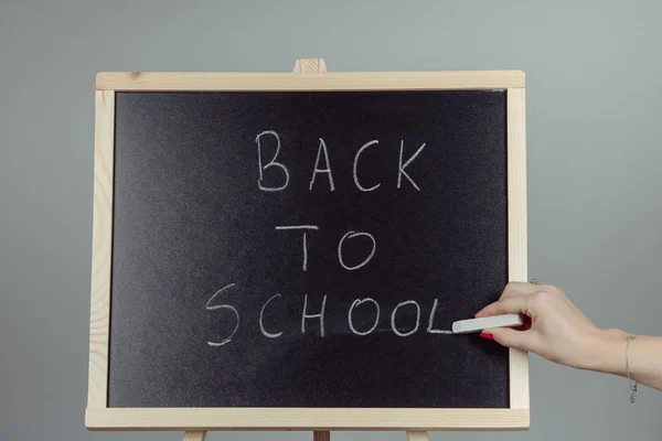 Back to school blackboard, chalkboard. Teacher writing back to school on black chalk board