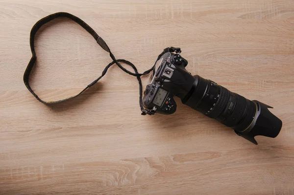 Digital photo camera on wooden desk table