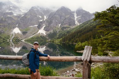 Adam gölde ve dağlarda dinleniyor. Güneşli manzara.