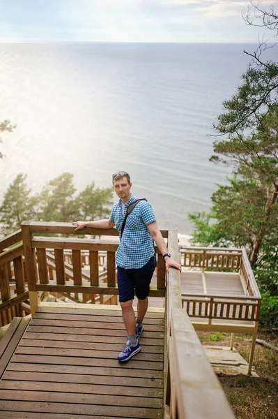 Man sitter på trä trappan i park och leende — Stockfoto