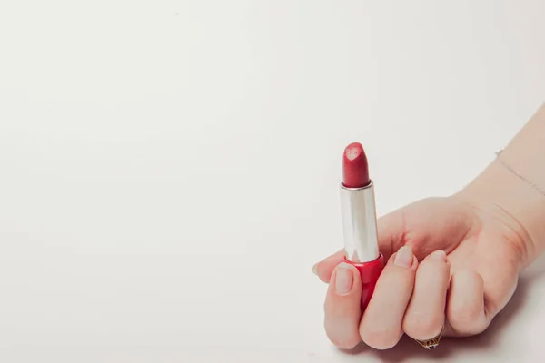 Lápiz labial rojo sostenido en la mano femenina, copyspace —  Fotos de Stock