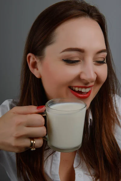 Mulher bonita com copo de leite sorrindo — Fotografia de Stock