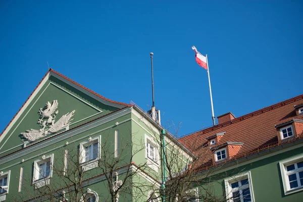Polish national flags on a building in a slight breeze — Stock Photo, Image