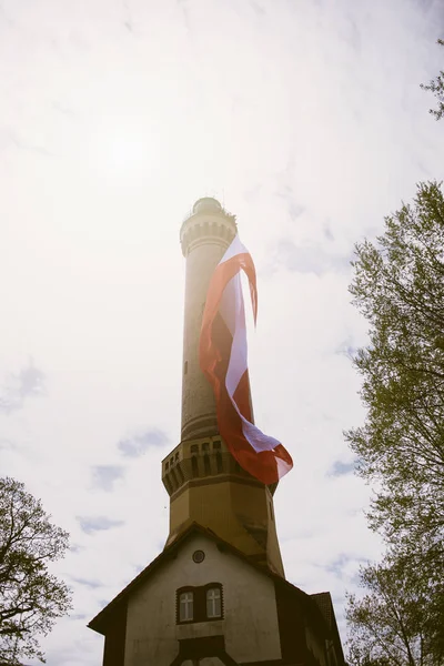 Eski Tuğla Taş Deniz Feneri lehçe ulusal bayrak ile — Stok fotoğraf