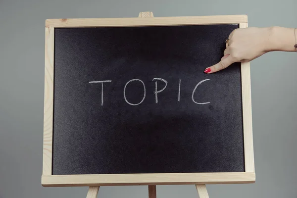 Topic written in white chalk on a black chalkboard — Stock Photo, Image