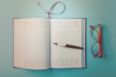 Mavi kağıt üzerine not defteri. Açık günlüğü ve kaydetmek için kalem