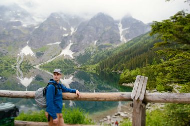 Adam gölde ve dağlarda dinleniyor. Güneşli manzara.