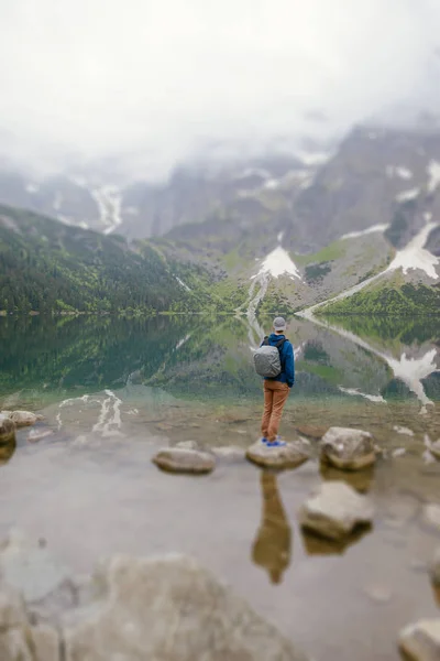 Muž relaxační na jezeře a hory slunné krajiny — Stock fotografie