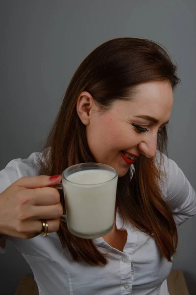 Menina alegre segurando caneca de leite na mão — Fotografia de Stock