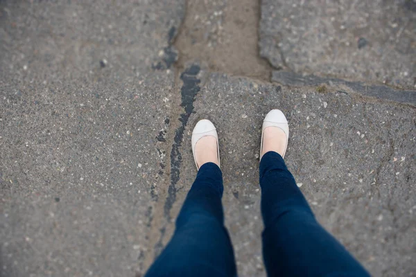 Ženské nohy a boty viděny shora na silnici — Stock fotografie