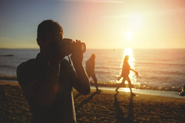 在海滩上的年轻摄影师的剪影 — 图库照片