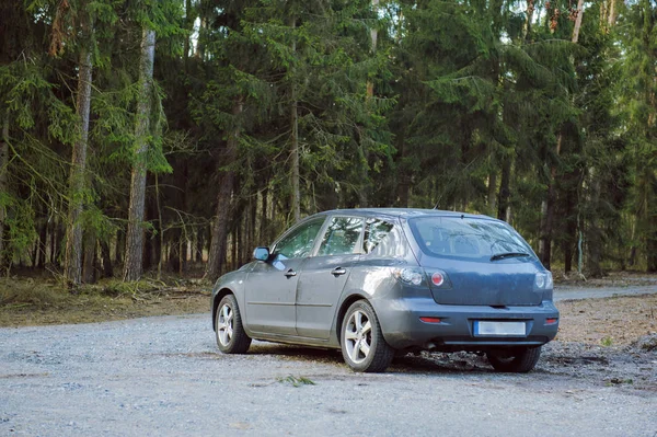 Samochód zaparkowany obok drewna — Zdjęcie stockowe