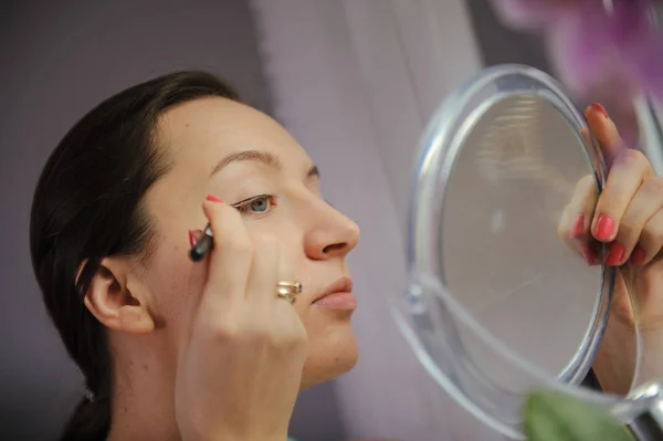 Mujer está haciendo maquillaje — Foto de Stock