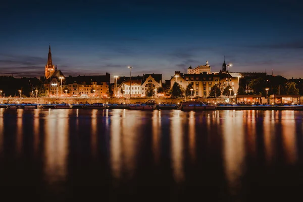 Szczecin. Éjszakai kilátás a folyón keresztül a megvilágított történelmi központba. Odra folyó. Chrobry töltések Szczecinben — Stock Fotó