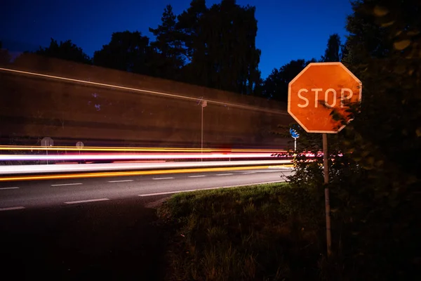 Autólámpák az autópályán, stoptábla az út szélén — Stock Fotó