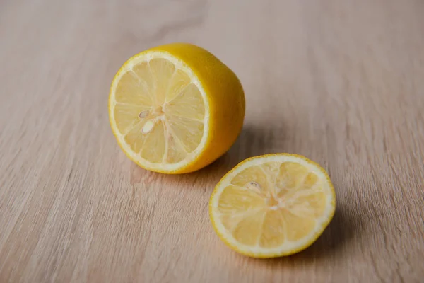 Fresh lemon with half isolated on wooden background — Stockfoto