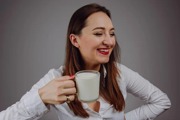 Menina alegre segurando caneca de leite na mão — Fotografia de Stock