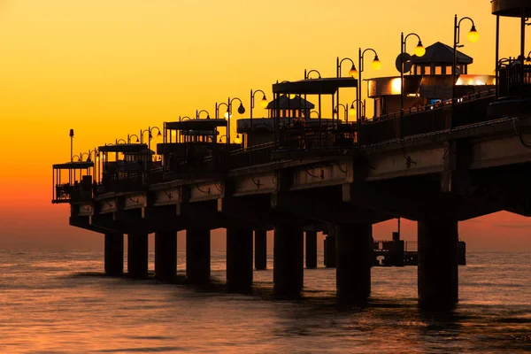 Morze Bałtyckie w pięknym zachodzie słońca na plaży w Międzyzdrojach. Polskiego wybrzeża Bałtyku. Słynne Miasto wśród turystów. Pier o zachodzie słońca — Zdjęcie stockowe