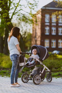Parktaki mutlu anne ve kız. Aile hayatı olan güzel doğa manzarası. Mutlu bir aile yeşil çimlerin üzerinde birlikte dinleniyor, dışarıda eğleniyor. Aile hayatında mutluluk ve uyum.