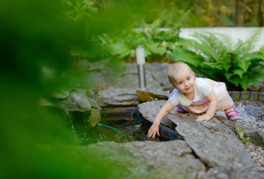 Çayırda gülümseyen kız kameraya bakıyor.