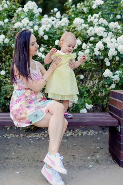 Happy mother and daughter in the park. Beauty nature scene with family outdoor lifestyle. Happy family resting together on the green grass, having fun outdoor. Happiness and harmony in family life — Stock Photo, Image