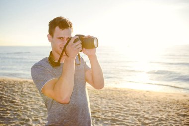 Kumsalda genç fotoğrafçı silüeti