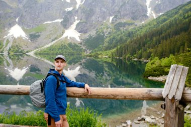 Adam gölde ve dağlarda dinleniyor. Güneşli manzara.