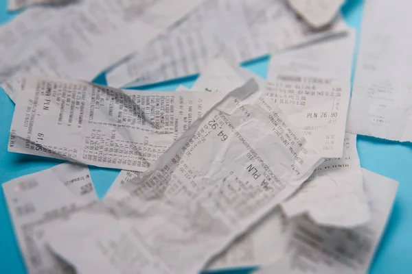 Pile of shopping receipts on blue background — Stock Photo, Image