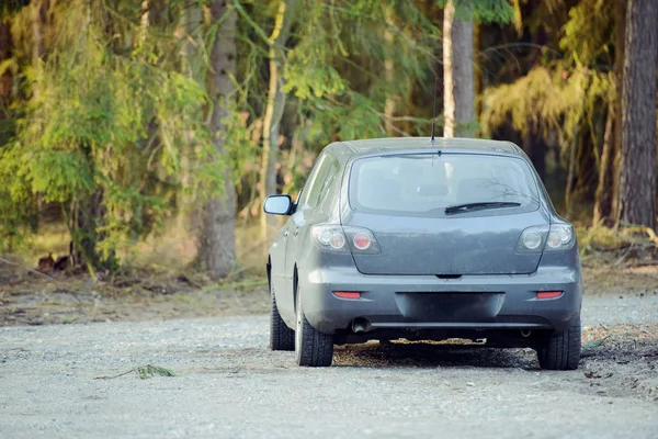 Carro estacionado ao lado da madeira — Fotografia de Stock