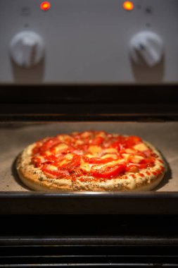 Fırında ev yapımı pepperoni pizza. Domates, peynir ve jambon ana malzemeler