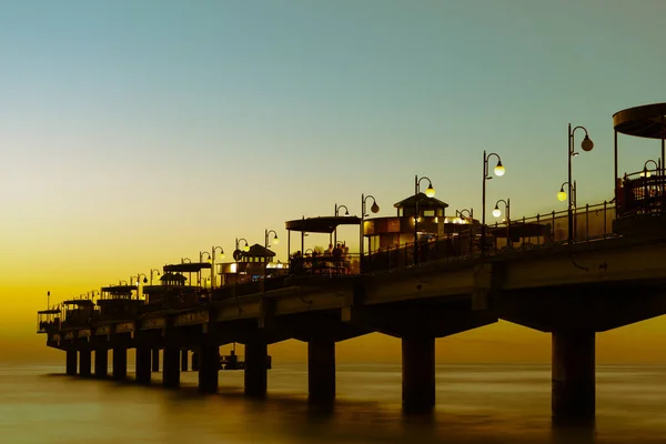 Morze Bałtyckie w pięknym zachodzie słońca na plaży w Międzyzdrojach. Polskiego wybrzeża Bałtyku. Słynne Miasto wśród turystów. Pier o zachodzie słońca — Zdjęcie stockowe