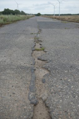 Yağmur ve kardan zarar gören bir yol, bakıma muhtaç. Kırık asfalt kaldırım bir çukur, araçlar için tehlikeli sonuçlanan.