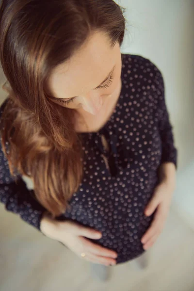Mujer embarazada se pega detrás del vientre —  Fotos de Stock