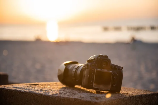 Cámara dslr profesional en la arena en la playa. A prueba de polvo — Foto de Stock